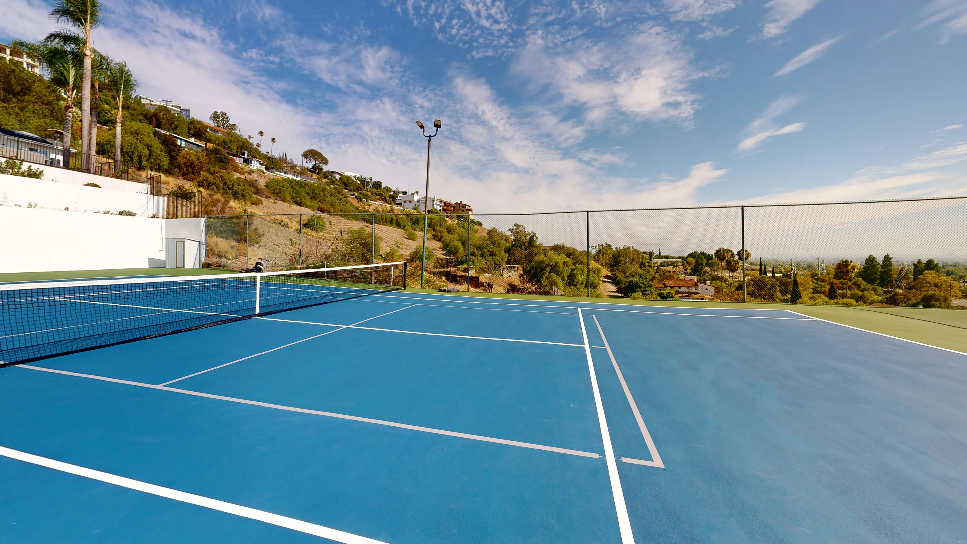 The private sport court, completely redone in July 2026 and striped for tennis and pickleball