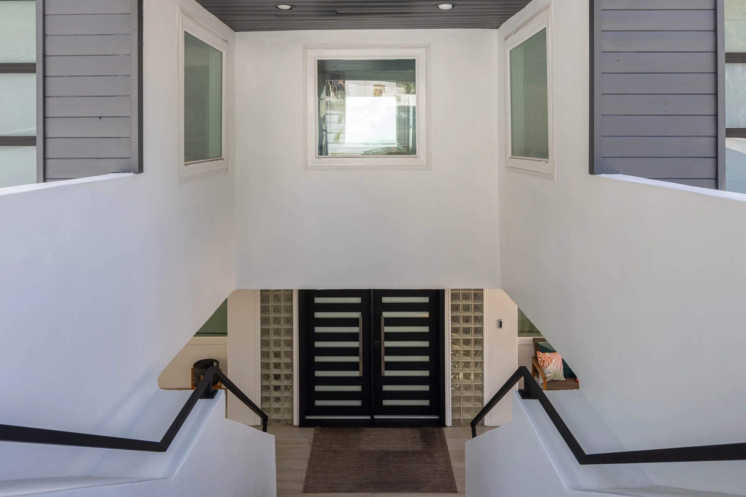 Two-story entry volume behind a dark slatted front door