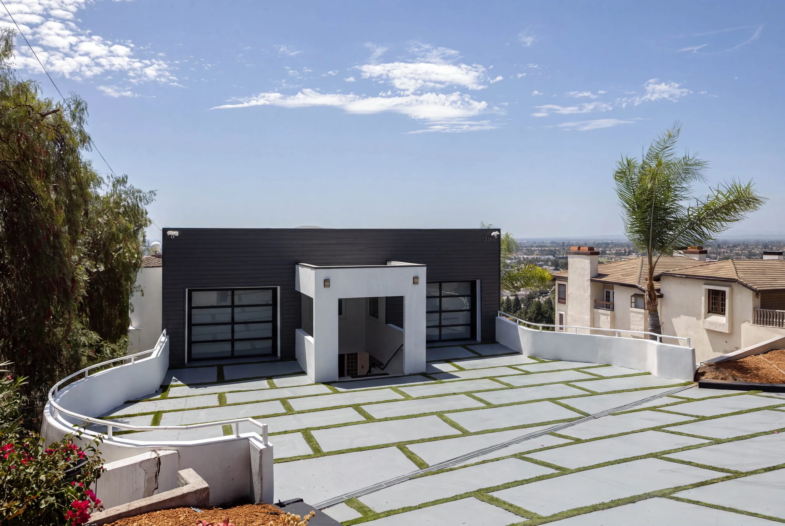 Street-level arrival: the black-clad garage wing and grass-joint paver motor court