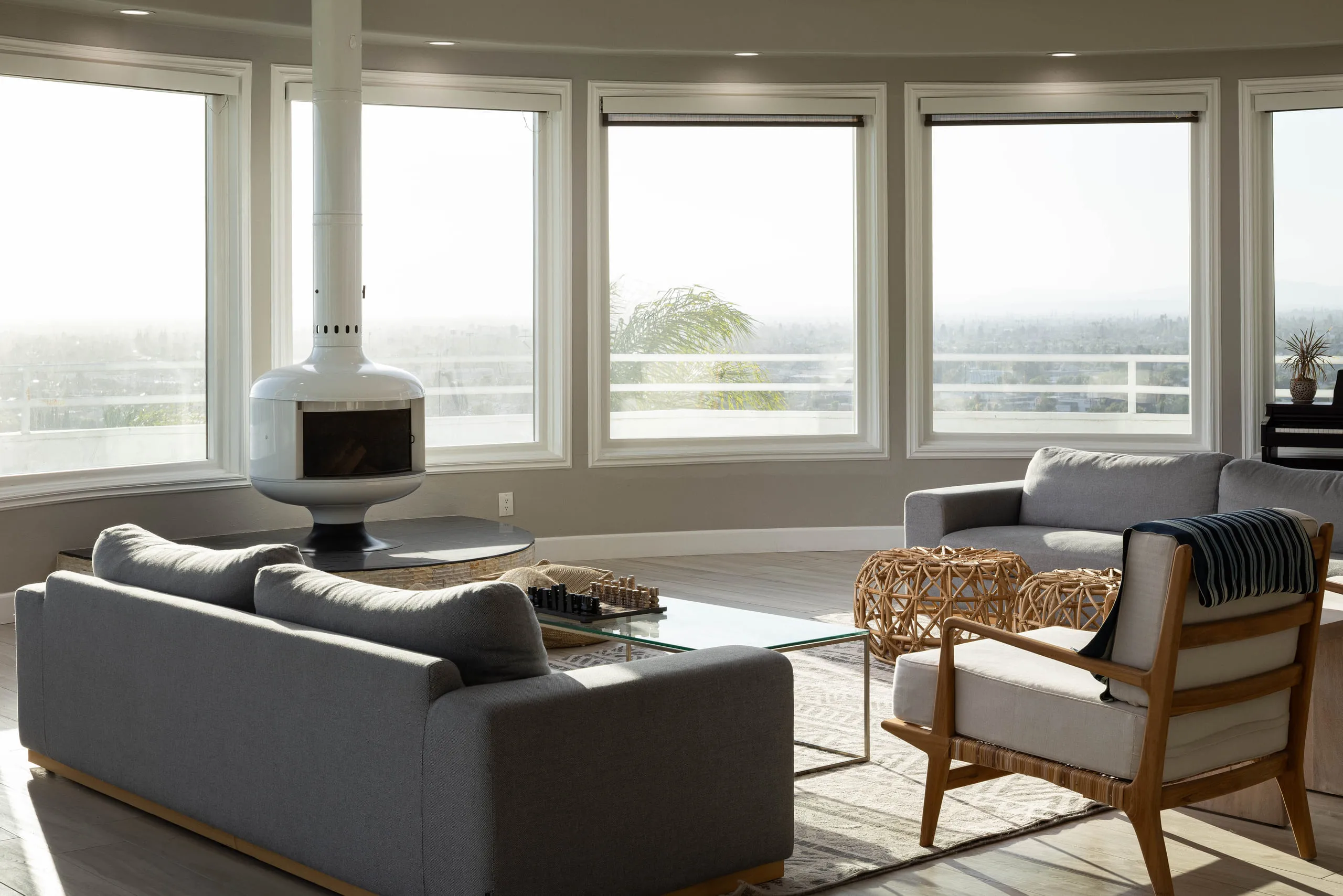 Great room with a freestanding fireplace inside the window curve