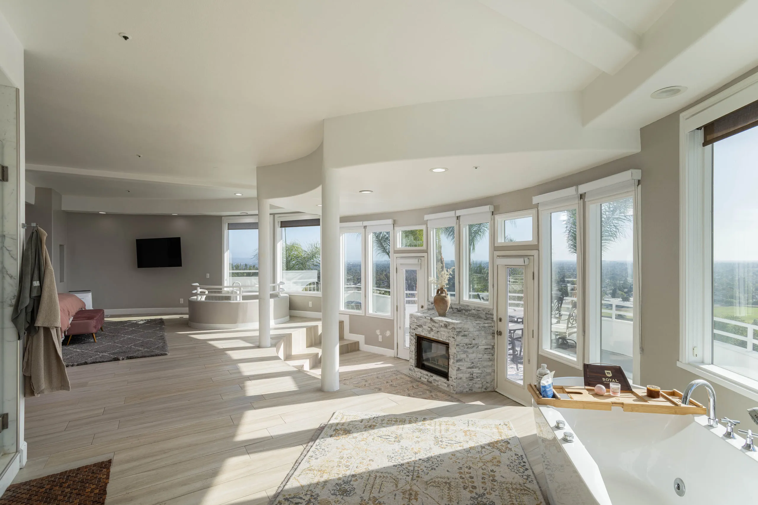 Primary suite — fireplace, soaking tub, and a wall of view windows